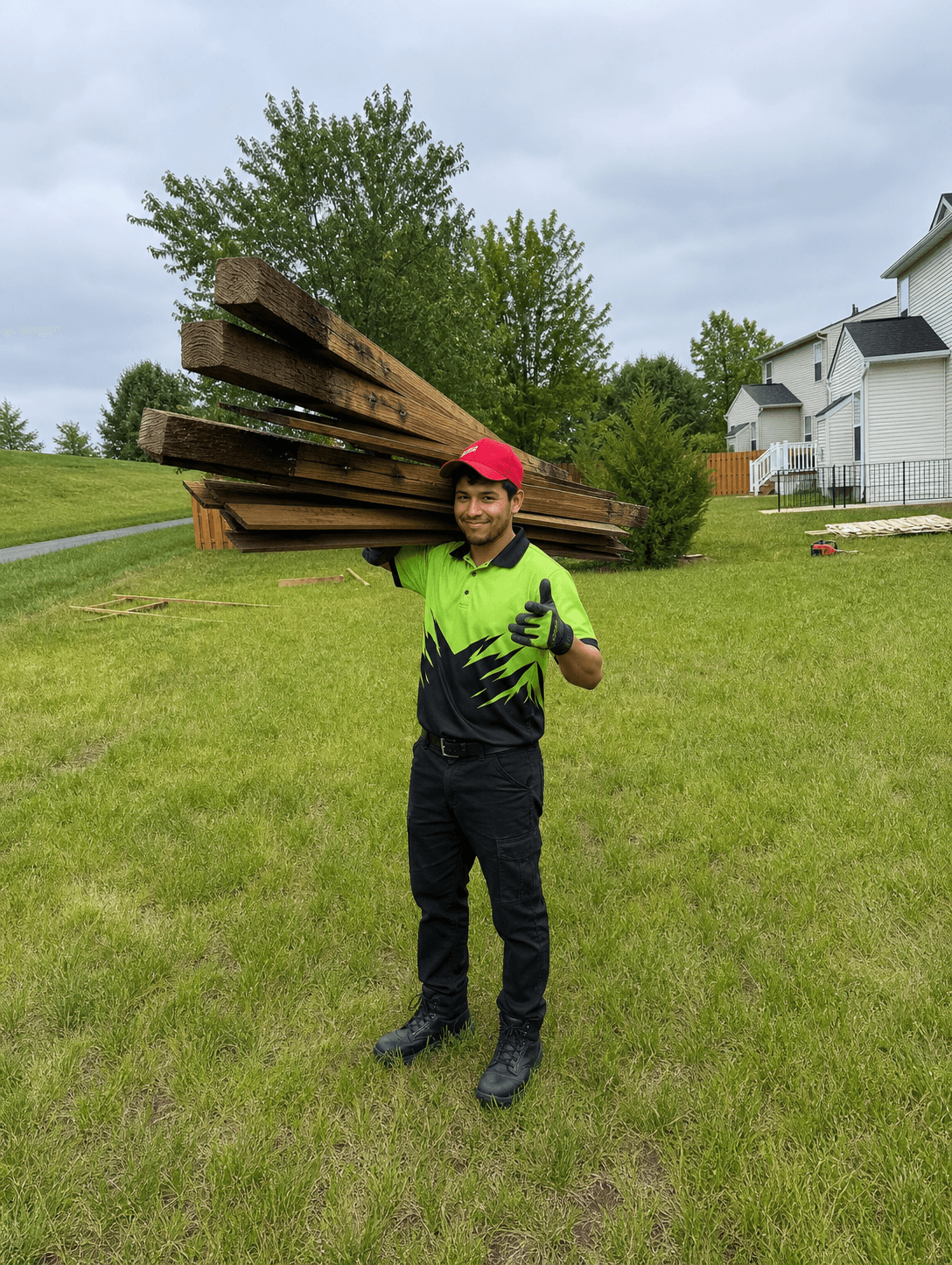 Wee Haul crew member carrying a load of old fence lumber out to the truck
