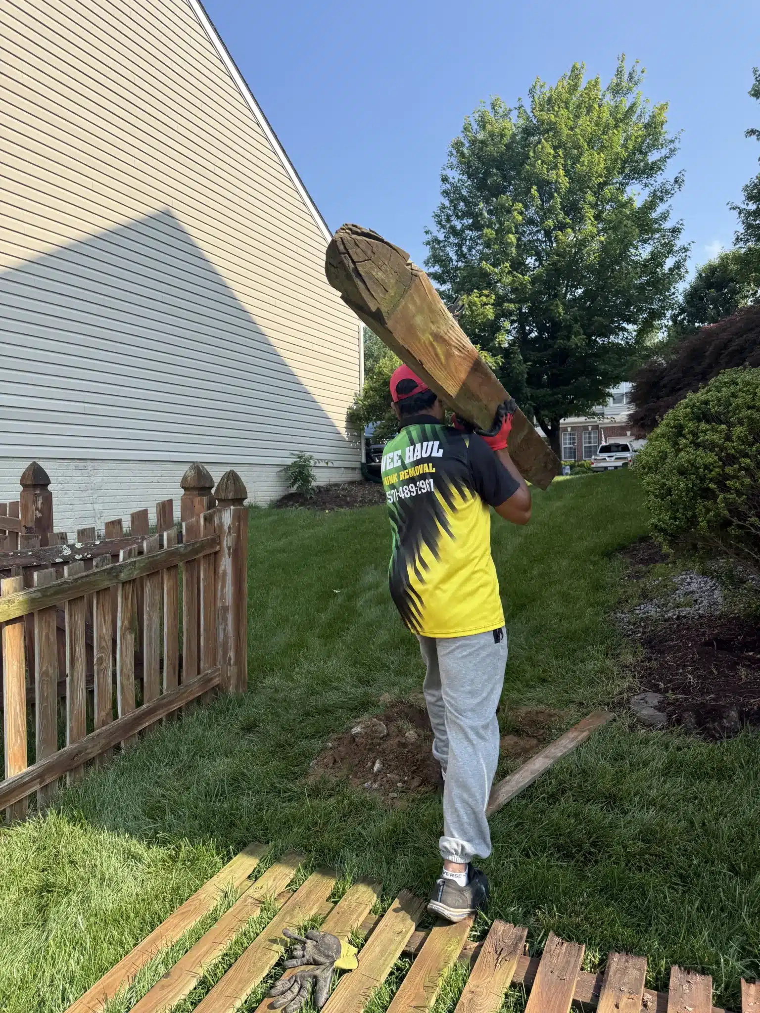 Wee Haul Junk Removal crew performing affordable fence removal in Fairfax, VA with concrete-set post extraction